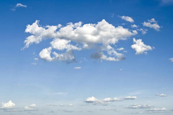 A photo of white clouds against a bright blue sky.